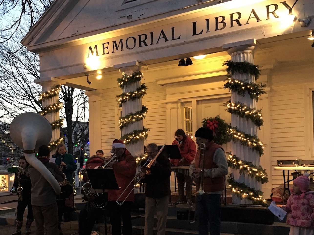 Community band playing at Christmas event in front of library.