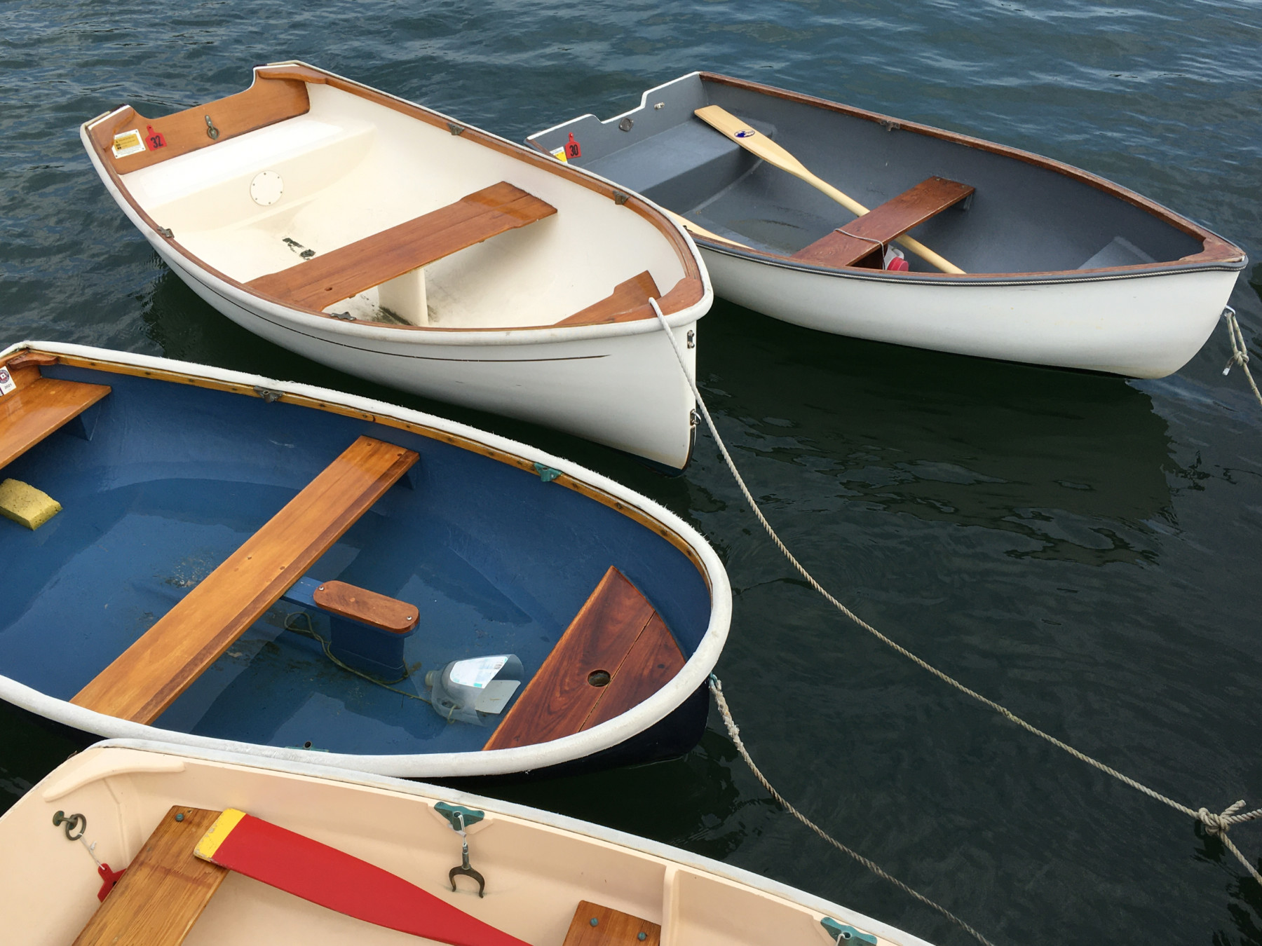 Four small rowboats tied to a dock