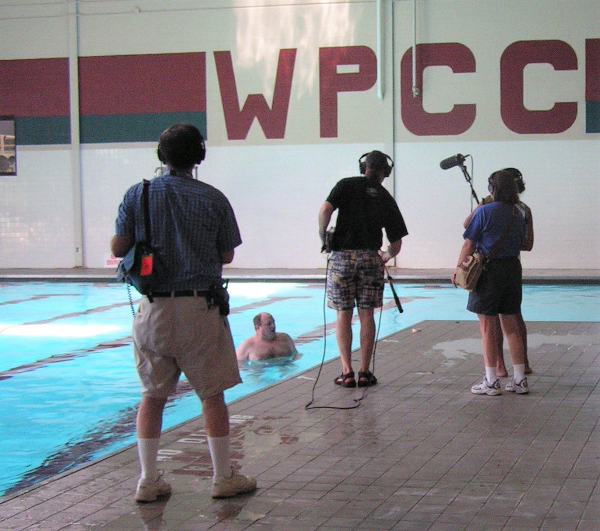 Two men and two women at a swimming pool recording the water sounds